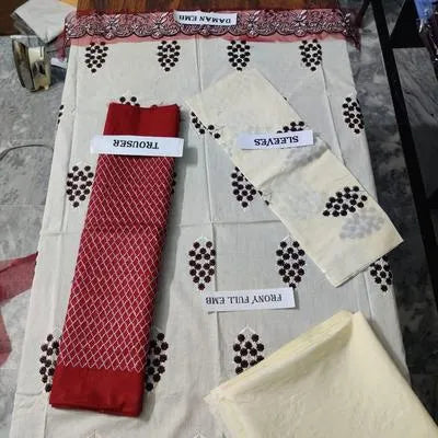 Two pieces of women's unstitched embroidered suit by UrbanBaazar, featuring intricate designs and vibrant colors.